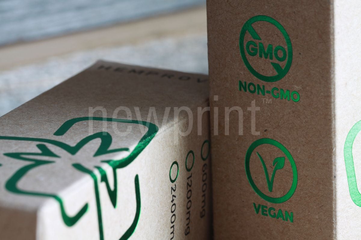 What is custom packaging - A close-up of two CBD oil packaging boxes made of kraft paper showing a big company logo.