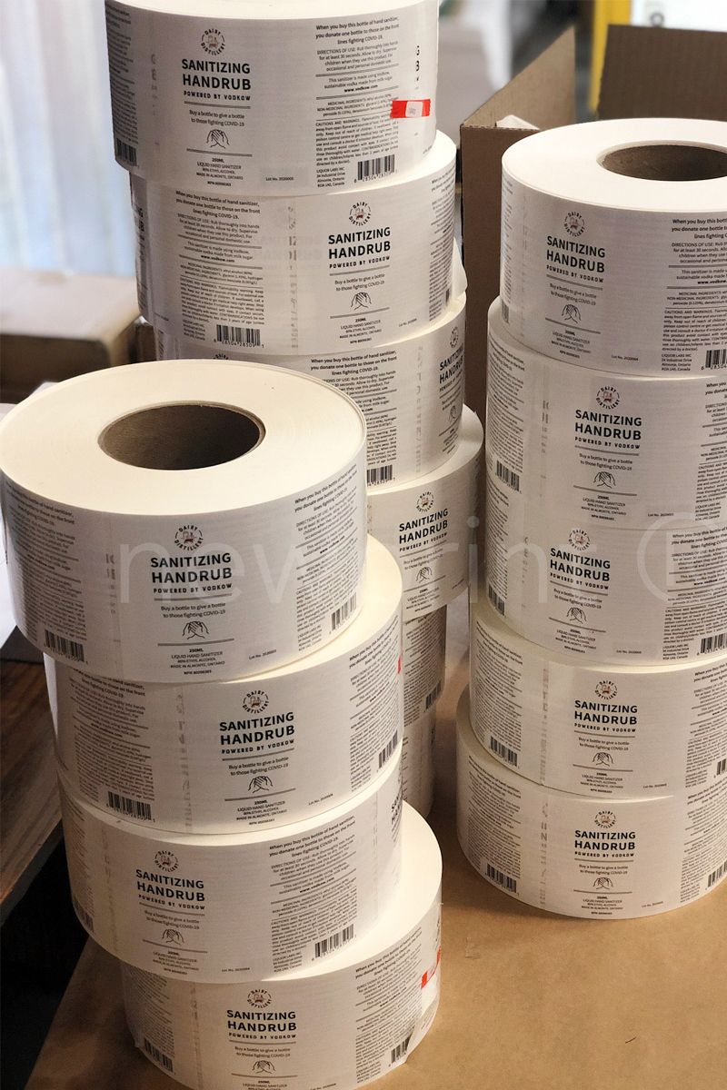 What is custom packaging - Three stacks of printed roll labels inside a print production facility.