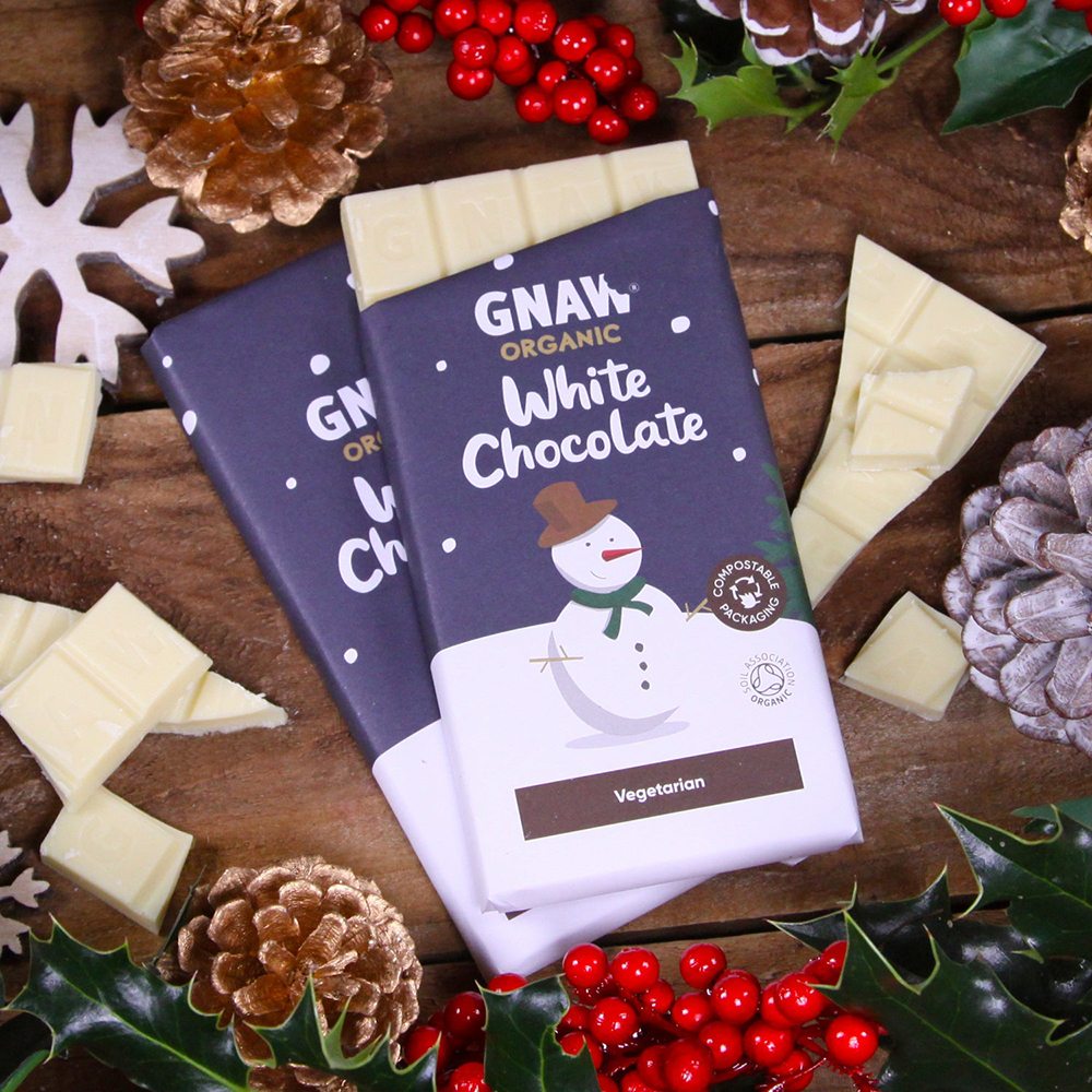 Two Gnaw white chocolate bars with holiday packaging