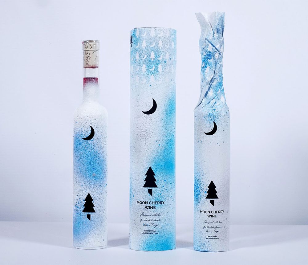 Three wine bottles in in white and blue holiday packaging