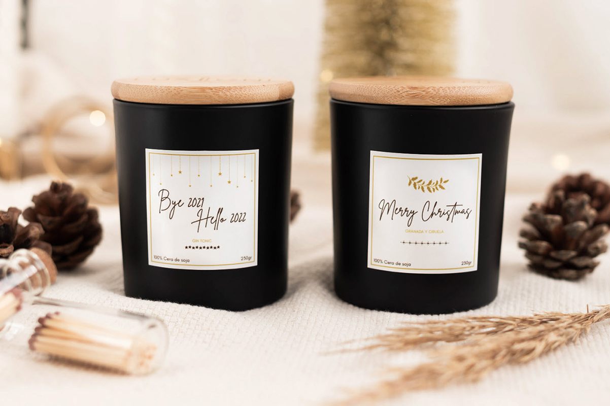 Christmas packaging design inspiration, two black candle jars with holiday-inspired labels.