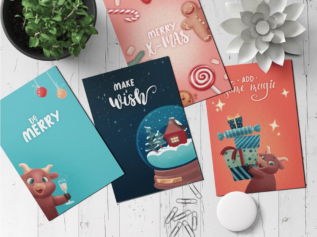 Christmas packaging design inspiration, four Christmas postcards on a white wooden table.