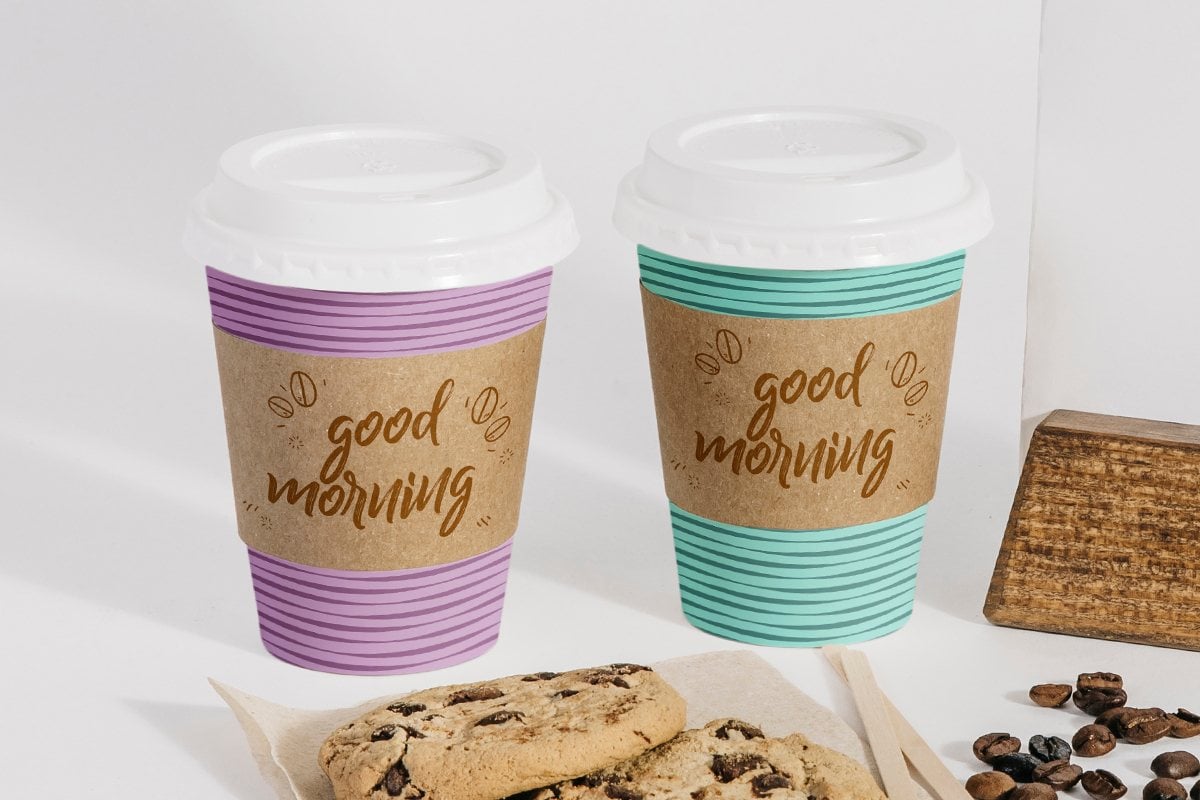 Image showing two different coloured coffee cups with coffee cup sleeves on them.