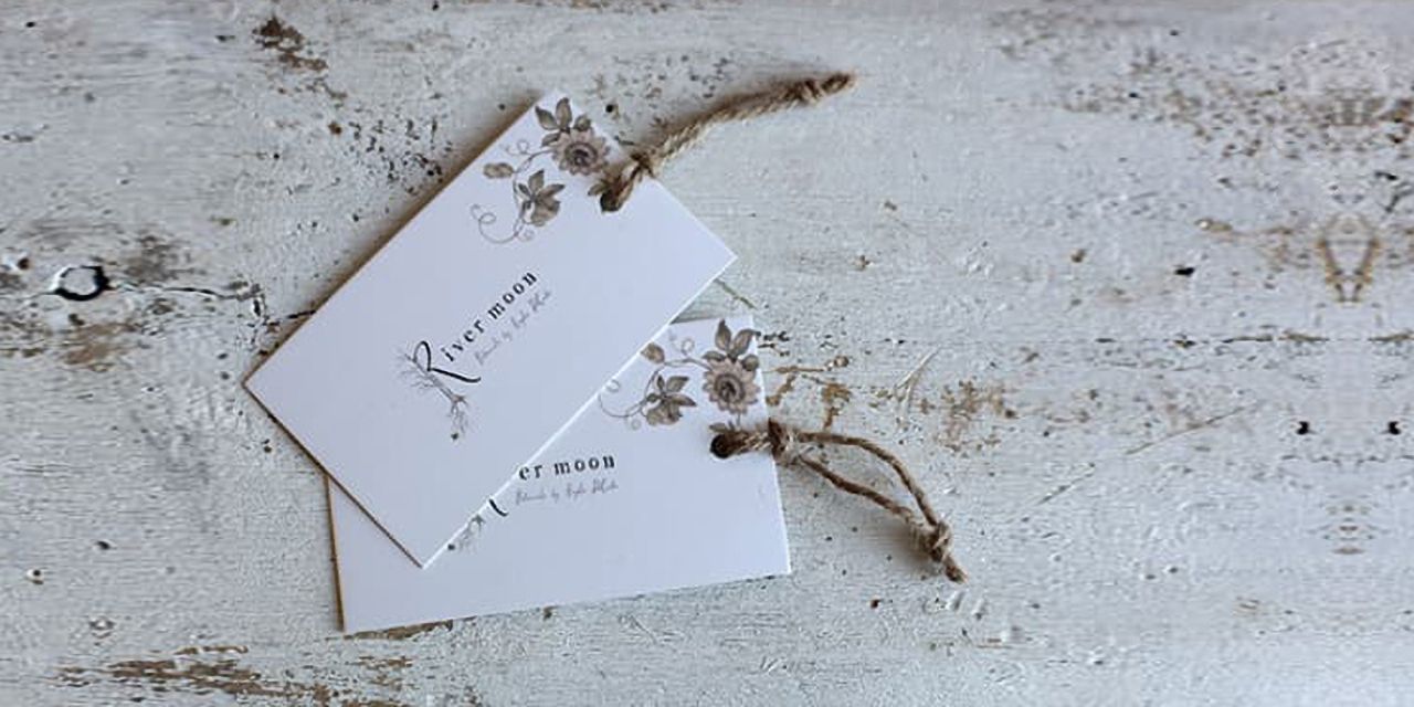 One of the hang tag examples - logo and small floral design on white background.