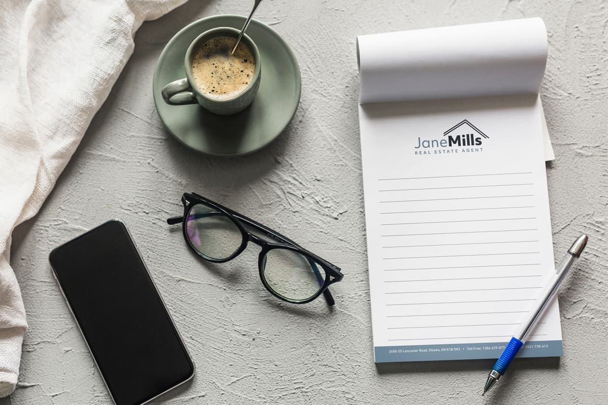 Image showing notepad with a pen on it with coffee, glasses and phone next to it.