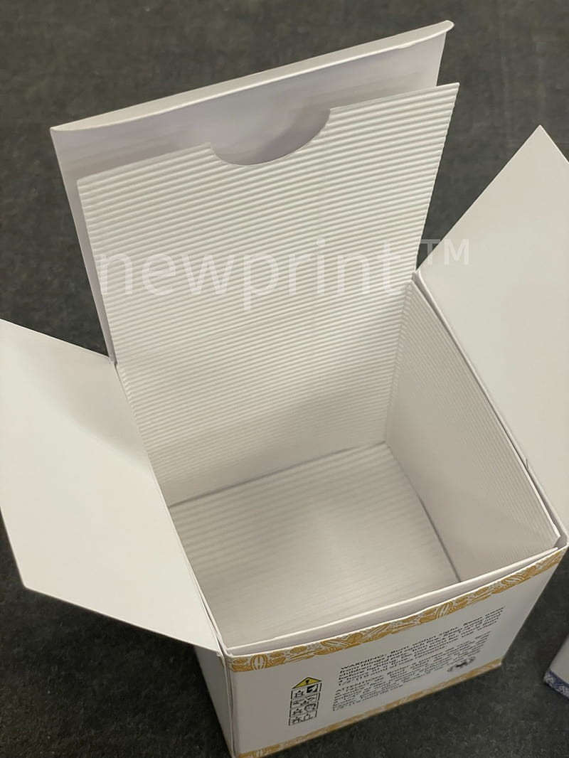 Opened paperboard candle box with the candle box insert inside.