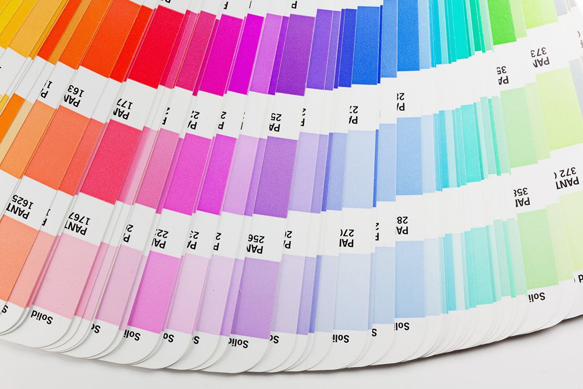 Spot color vs CMYK, a closeup shot of a Pantone book showing various different shades of colors.