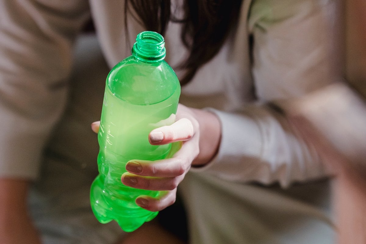 Types of packaging products - a hand holding green PET bottle.